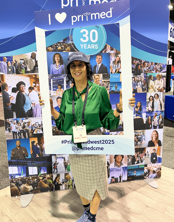 Conference attendee holding a frame that says I Love Pri-Med.