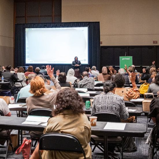 attendees raising hands during an industry theatersession